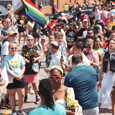 A parade of people holding up rainbow flags