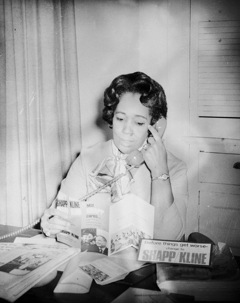 Black-and-white vintage photo of a Black woman talking on a retro telephone